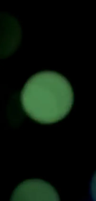 Abstract green bokeh wallpaper with soft blurred circles on a dark background.