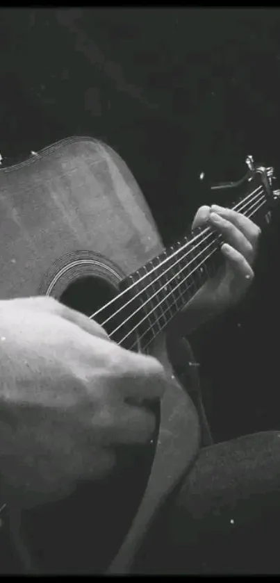 Monochrome mobile wallpaper of an acoustic guitar being played.