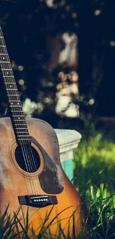 Acoustic guitar leaning against a tree among lush green grass.