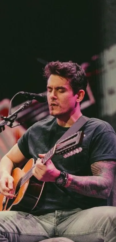 Musician playing acoustic guitar live on stage.