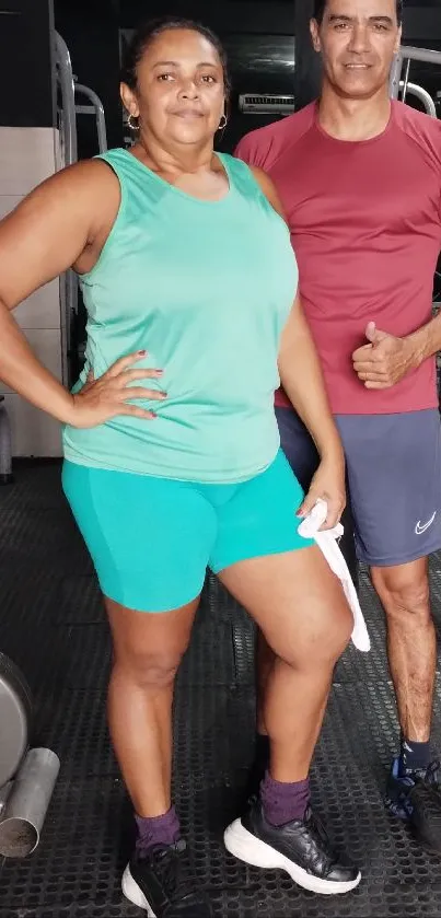 Two people posing in colorful workout attire at the gym.