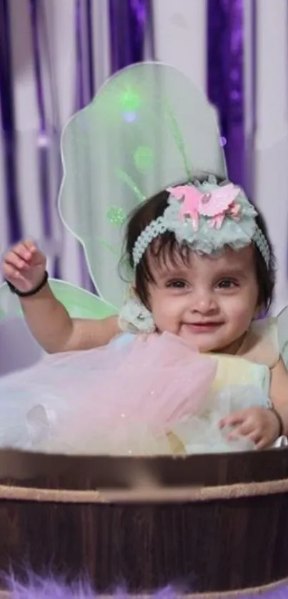 Adorable baby dressed as a fairy in a purple-themed background.