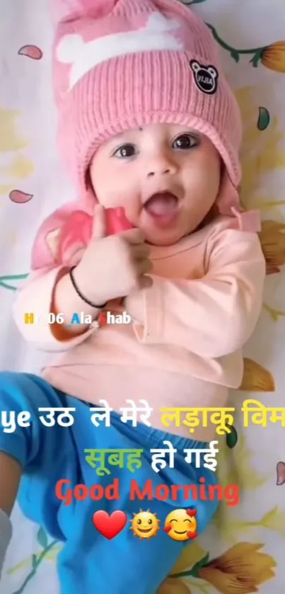 Adorable baby wearing a pink hat with Good Morning text.