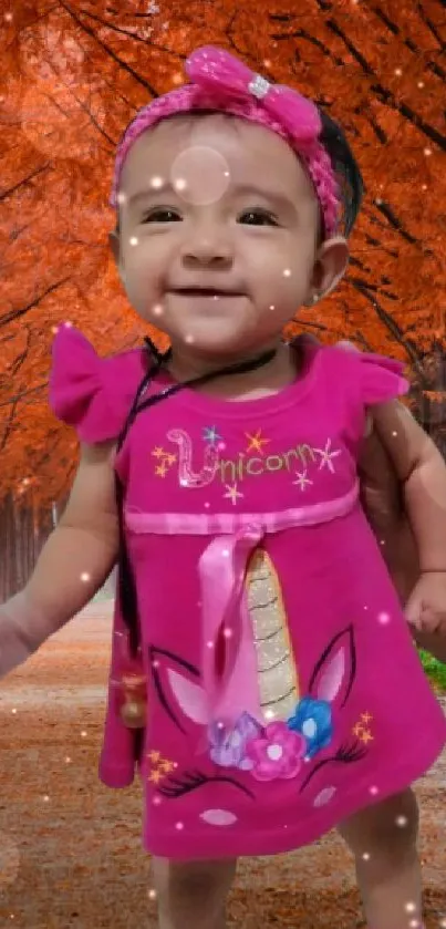 Smiling baby in pink dress on autumn path