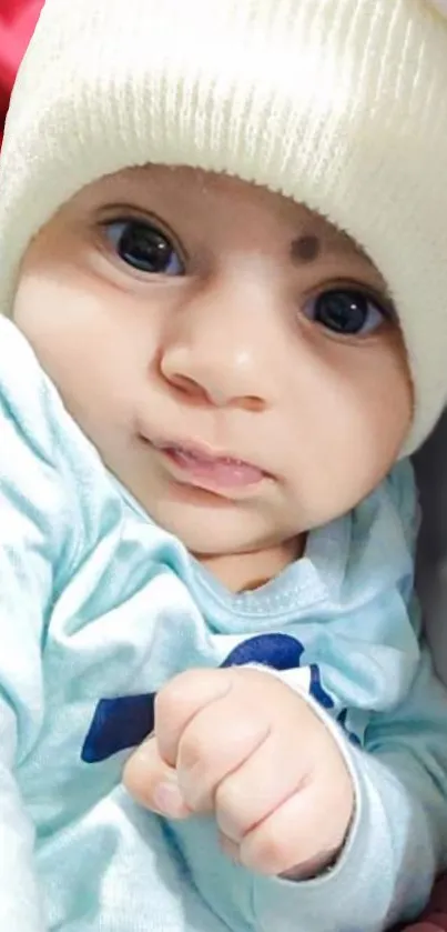 Adorable baby wearing a cozy hat with light blue outfit.