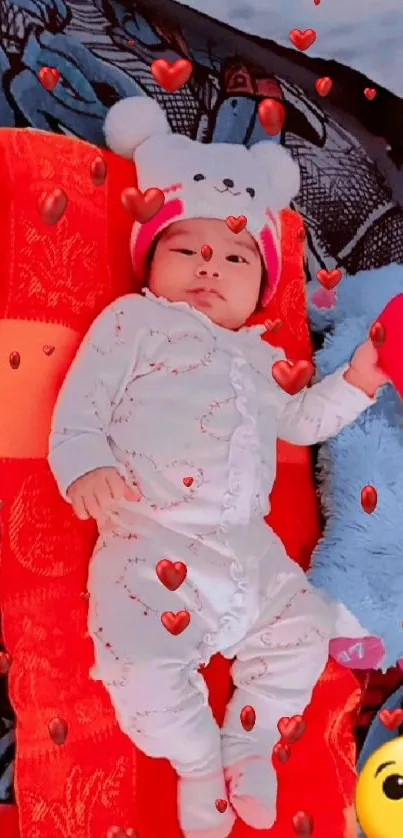 Adorable baby in cozy outfit on red cushion with plush toys.