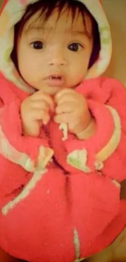 Adorable baby in a coral pink cozy hoodie, perfect for mobile wallpaper.