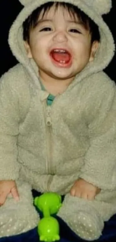 Adorable baby in a fluffy bear costume smiling joyfully.