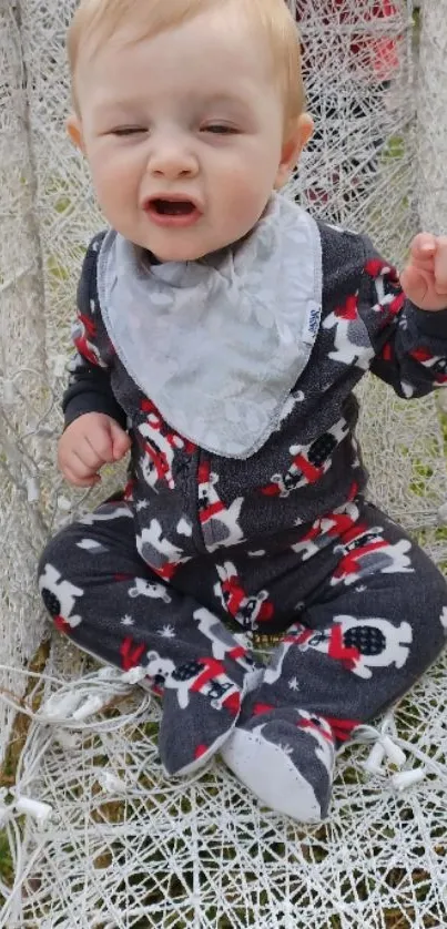 Cute baby in festive attire sitting and smiling at the camera.