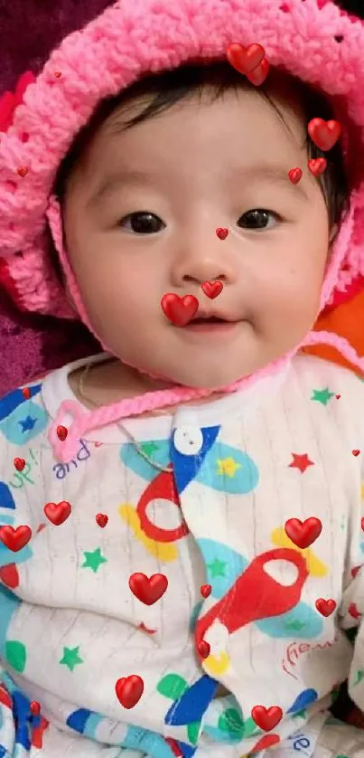 Cute baby with pink hat and colorful outfit in a joyful setting.