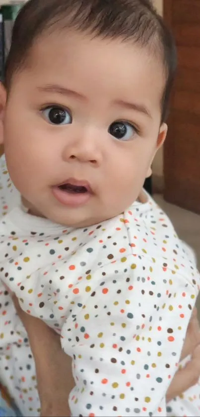 Baby with a curious look wearing polka dot outfit