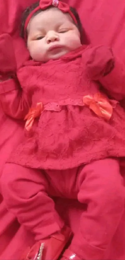 Baby in a red outfit on red background.