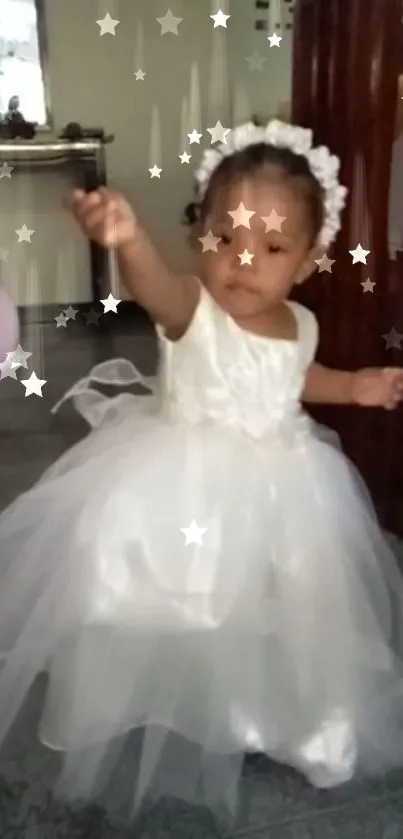 Adorable baby in white dress with surrounding stars.