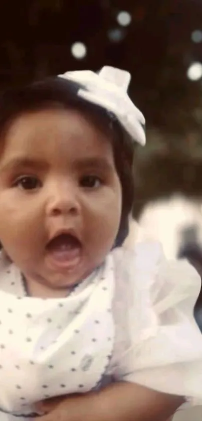 Cute baby with white bow smiling cheerfully.