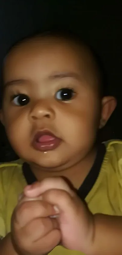 Close-up of an adorable baby with a light brown shirt.