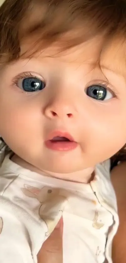 Close-up of a cute baby with blue eyes and brown hair.