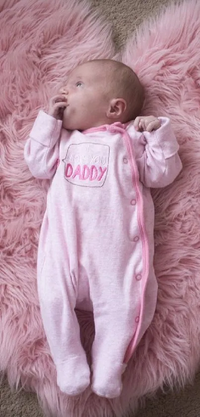 Cute baby lying on a pink heart rug, perfect for mobile wallpaper.