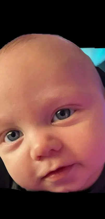 Close-up of a cute baby with blue eyes and a gentle smile on a wallpaper.