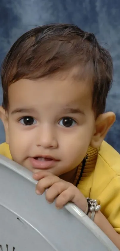 Adorable baby with yellow shirt and blue background