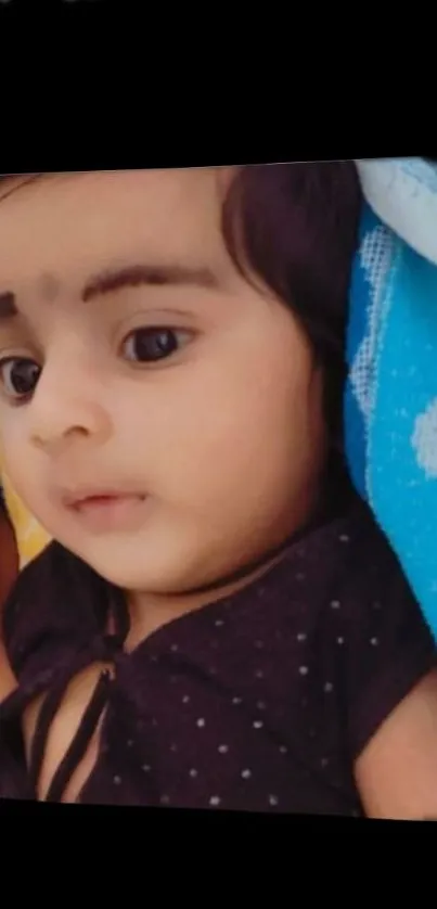 Adorable baby resting peacefully on a colorful blanket.