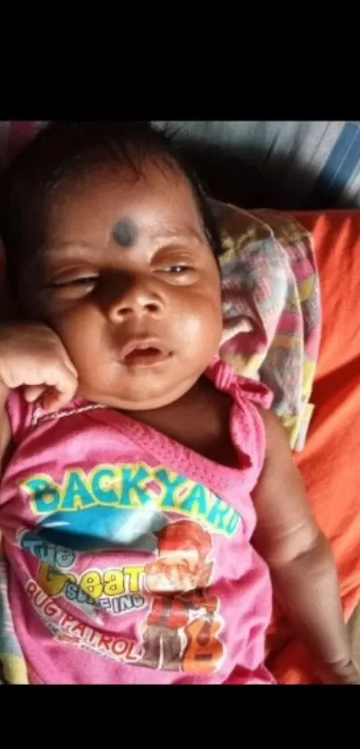 Adorable baby sleeping in colorful attire.