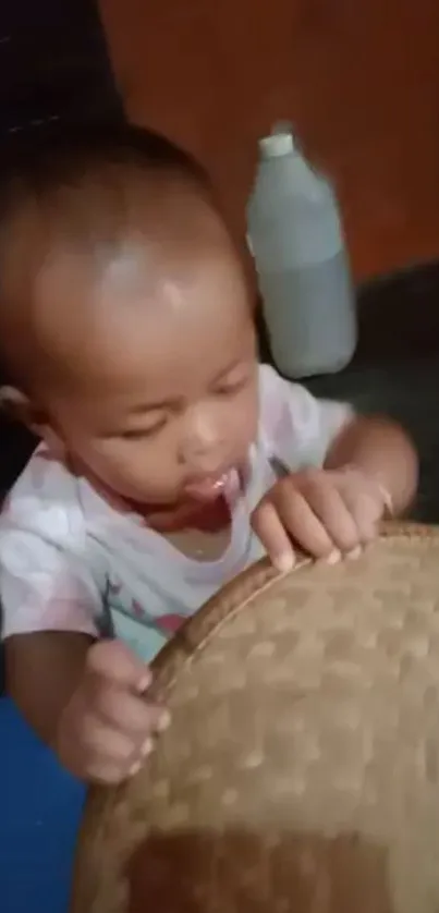 Cute baby interacting with a basket in a cozy setting.