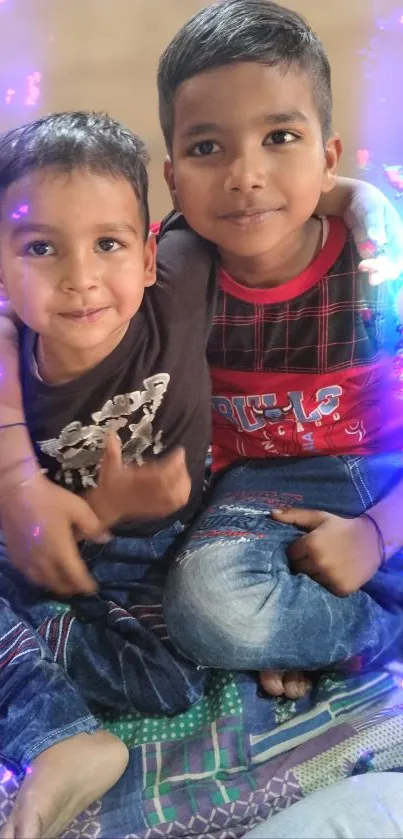 Two young brothers sit together, smiling with a neon glow.