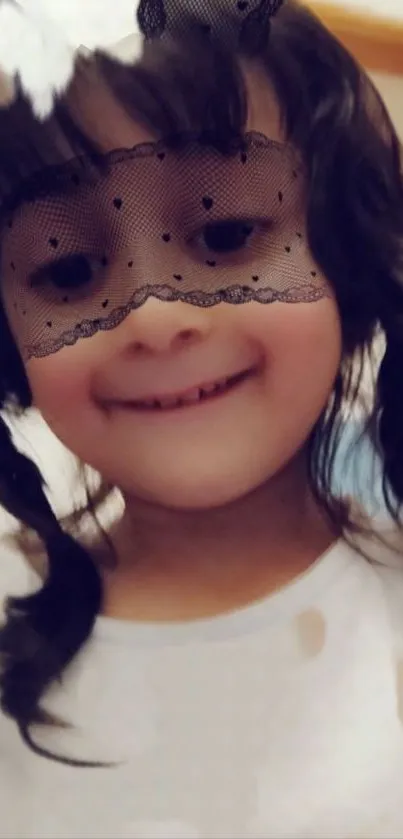 Smiling child wearing a black lace veil, adding playful charm.