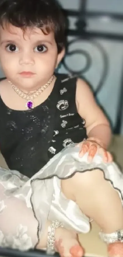 Adorable child in elegant outfit sitting gracefully.