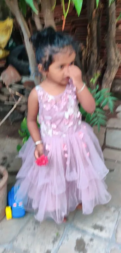 Young girl in pink dress with garden background.