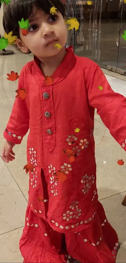 Child in a bright red outfit standing indoors.