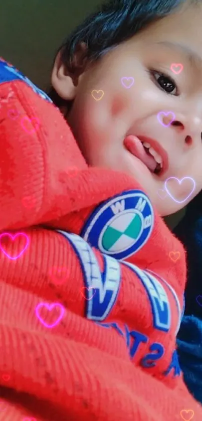 Joyful child smiling in red sweater.