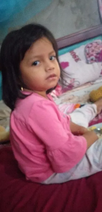 Adorable child sitting on a cozy bed with toys.