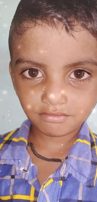 Adorable child with sparkling eyes in a light blue-themed portrait.