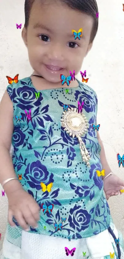 Smiling child in a floral outfit with colorful butterflies.