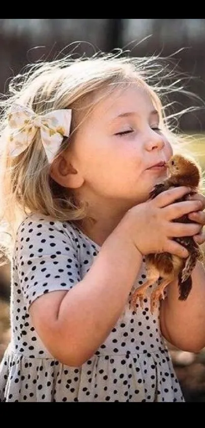 Adorable child holding a chick outdoors in warm sunlight.