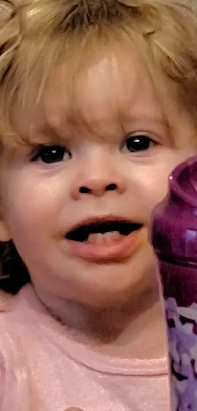 Cute toddler smiling with a purple toy.