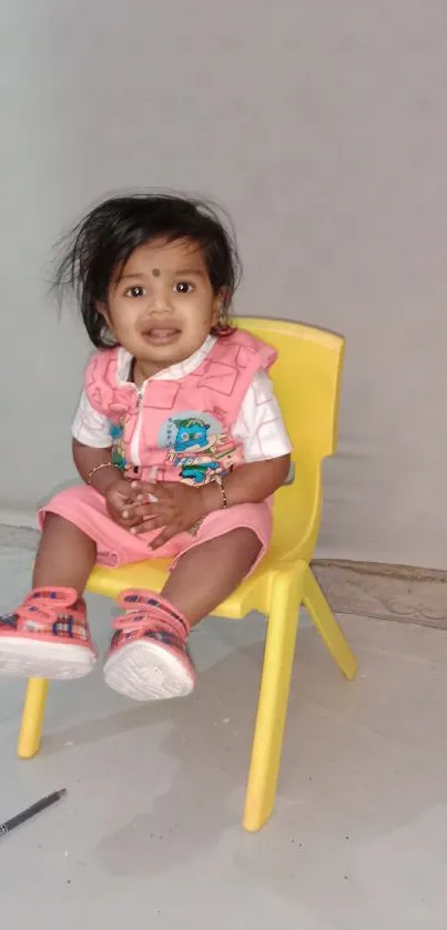 Adorable child smiling on a yellow chair.