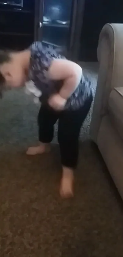 Adorable toddler standing on carpet next to sofa, exploring her surroundings.