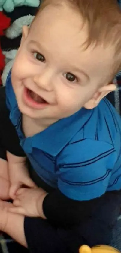 Adorable toddler wearing a blue outfit with a joyful expression.