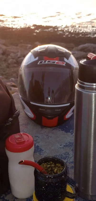 Helmet and gear by the coast at sunset.