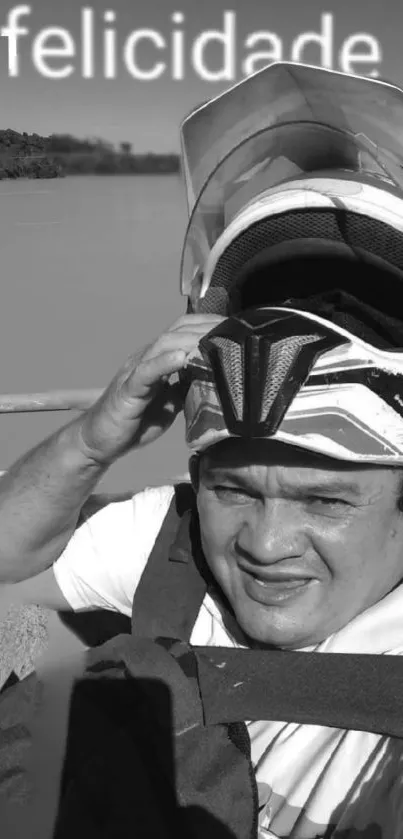 Man in motorcycle helmet by a river with "felicidade" text.