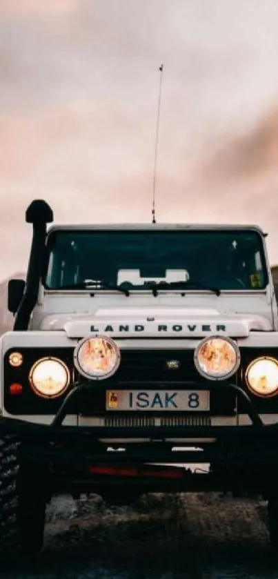 Front view of white Land Rover on mountain trail.