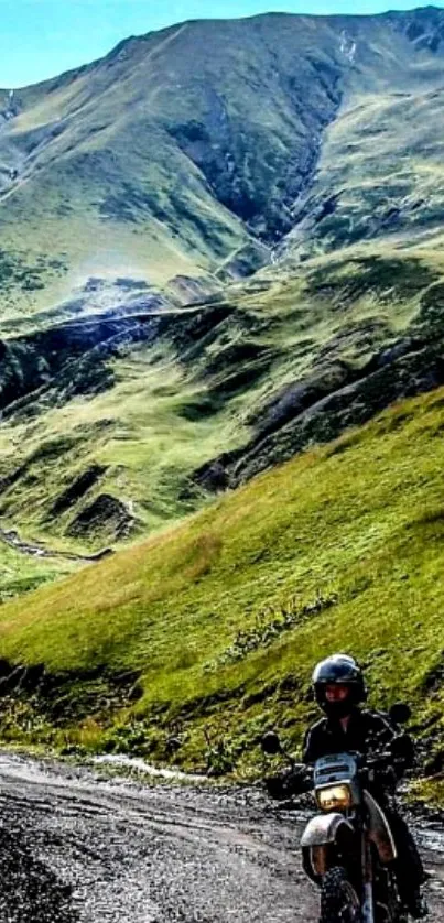 Motorcyclist on a scenic mountain path over lush green hills.