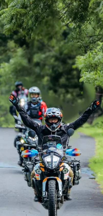 Motorcyclist leading a group ride through lush greenery.