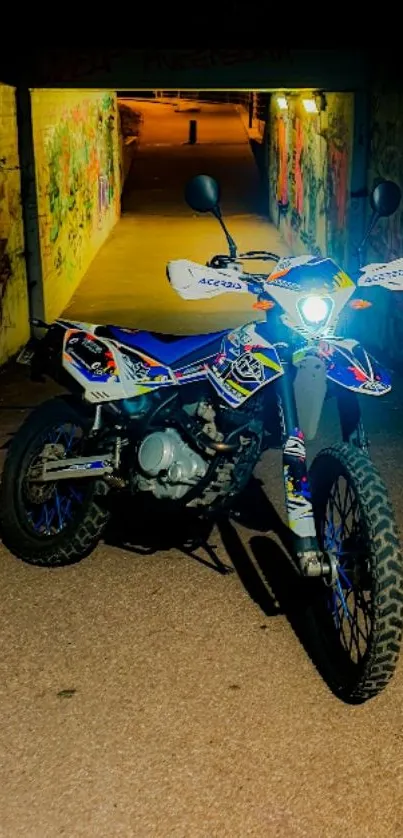 Motorcycle in graffiti-filled tunnel at night.