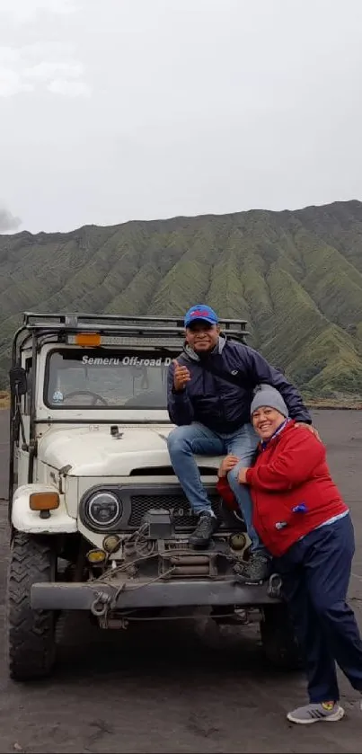 Jeep parked on rugged terrain before a mountain backdrop.