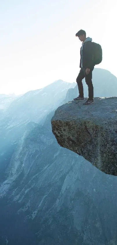 Adventurer standing on a mountain cliff edge with a vast landscape view.