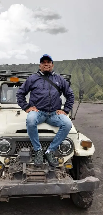 Person sitting on jeep in striking mountain scenery.