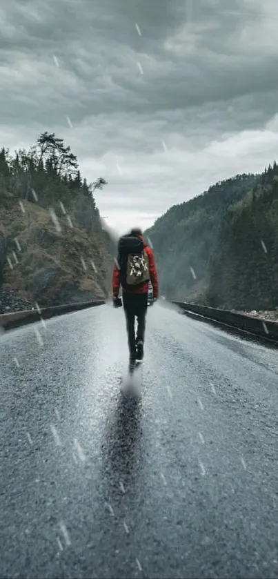 Man walking on rainy mountain road with backpack.